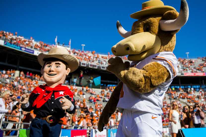 Lil' Big Tex and Hook Em' dance on the field before the 2016 AT&T Red River Showdown between...