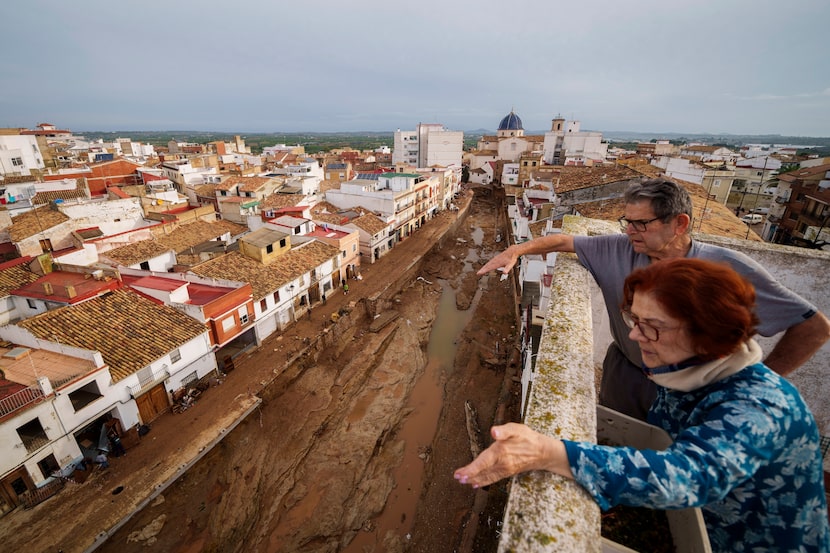 Dos personas observan las zonas afectadas por las inundaciones en Chiva, cerca de Valencia,...