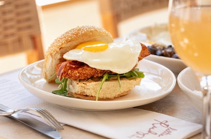 Little Ruby's egg sandwich is stacked with bacon, tomatoes, arugula, spicy relish and hash...