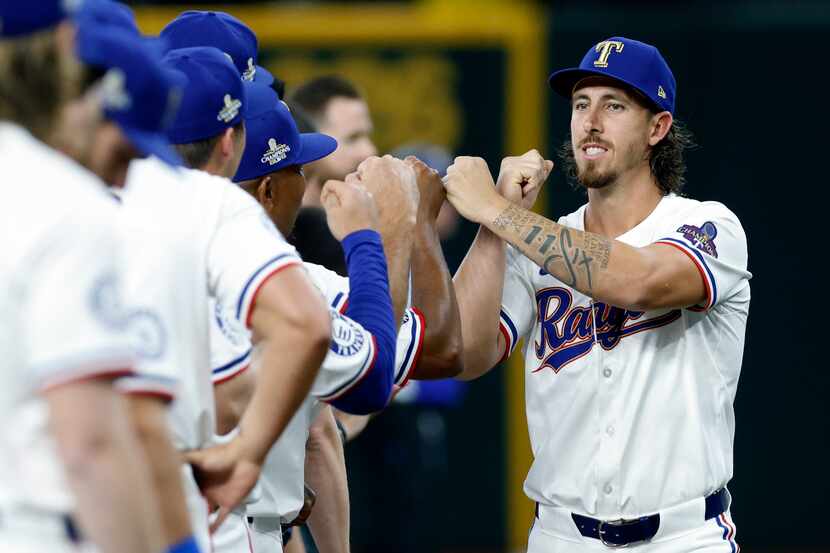 Texas Rangers starting pitcher Michael Lorenzen (right) fist bumps teammates as he’s...