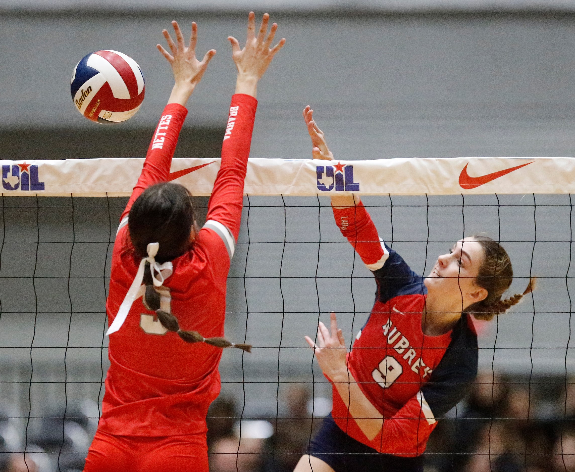 Aubrey High School’s Annaleise Sevier (9) gets a hit by Bellville High School’s Sybil McKay...