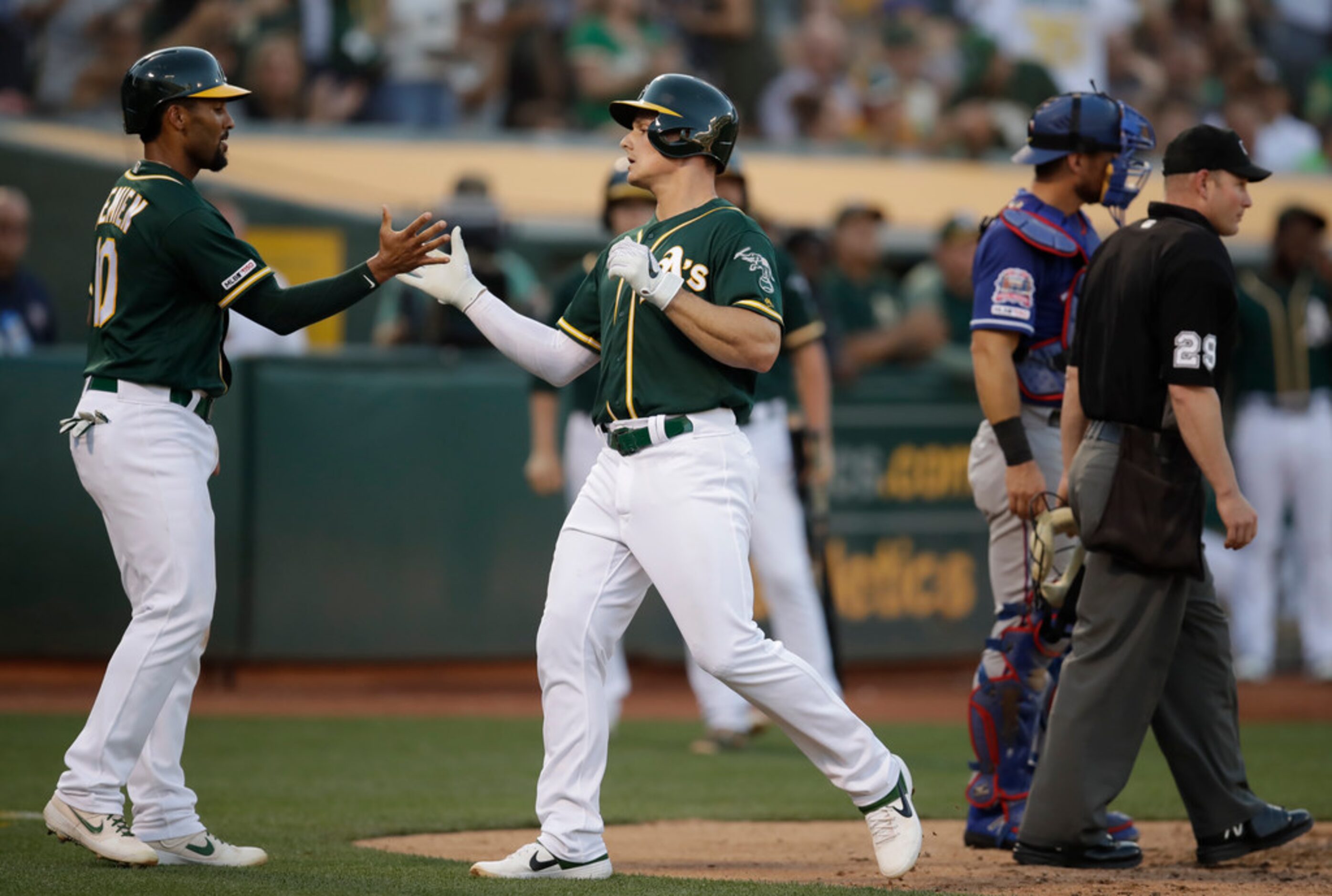 Oakland Athletics' Matt Chapman, center, celebrates with Marcus Semien, left, after hitting...