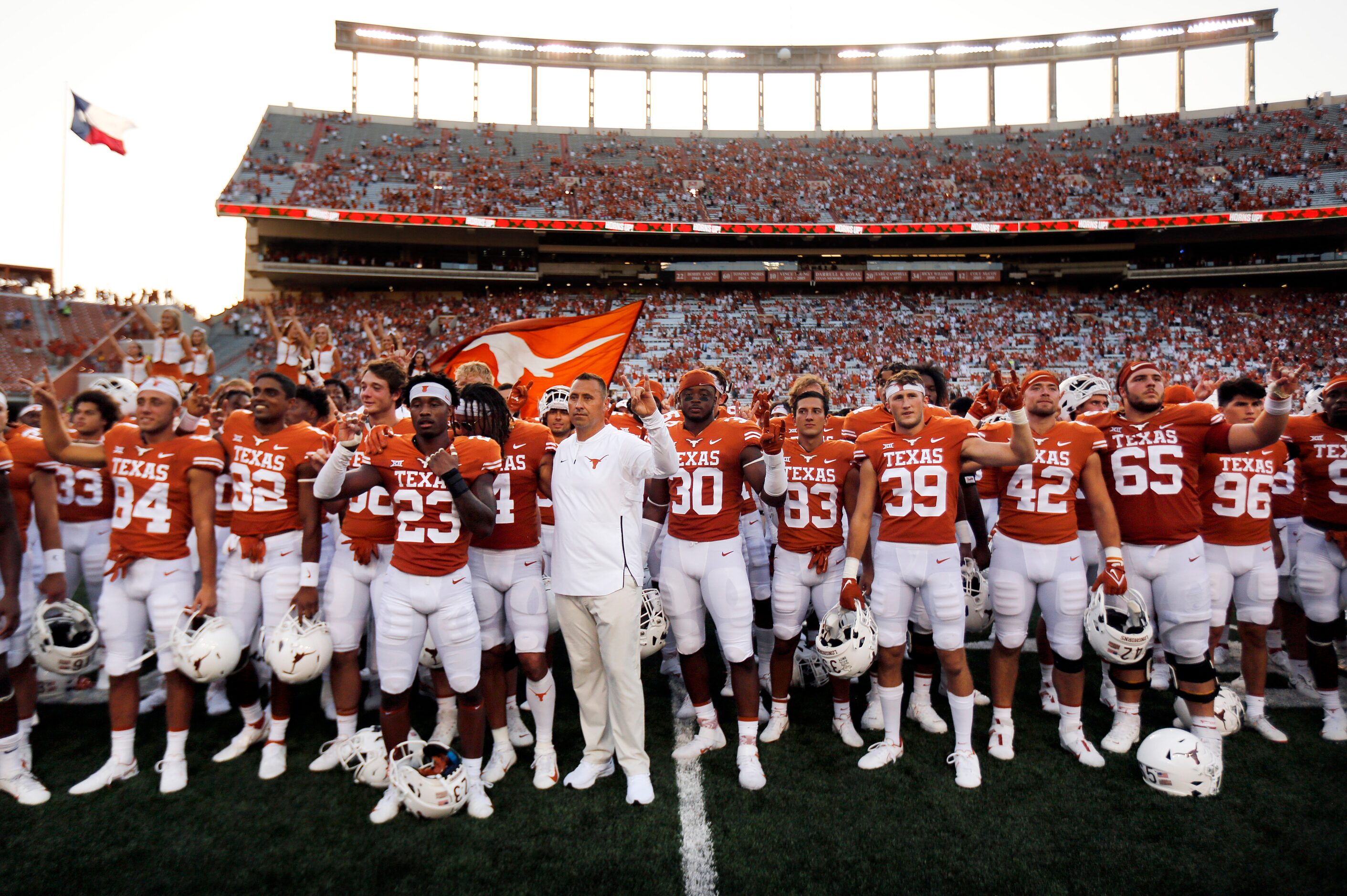 Texas Longhorns head coach Steve Sarkisian (center) and his players sing 'The Eyes of Texas'...