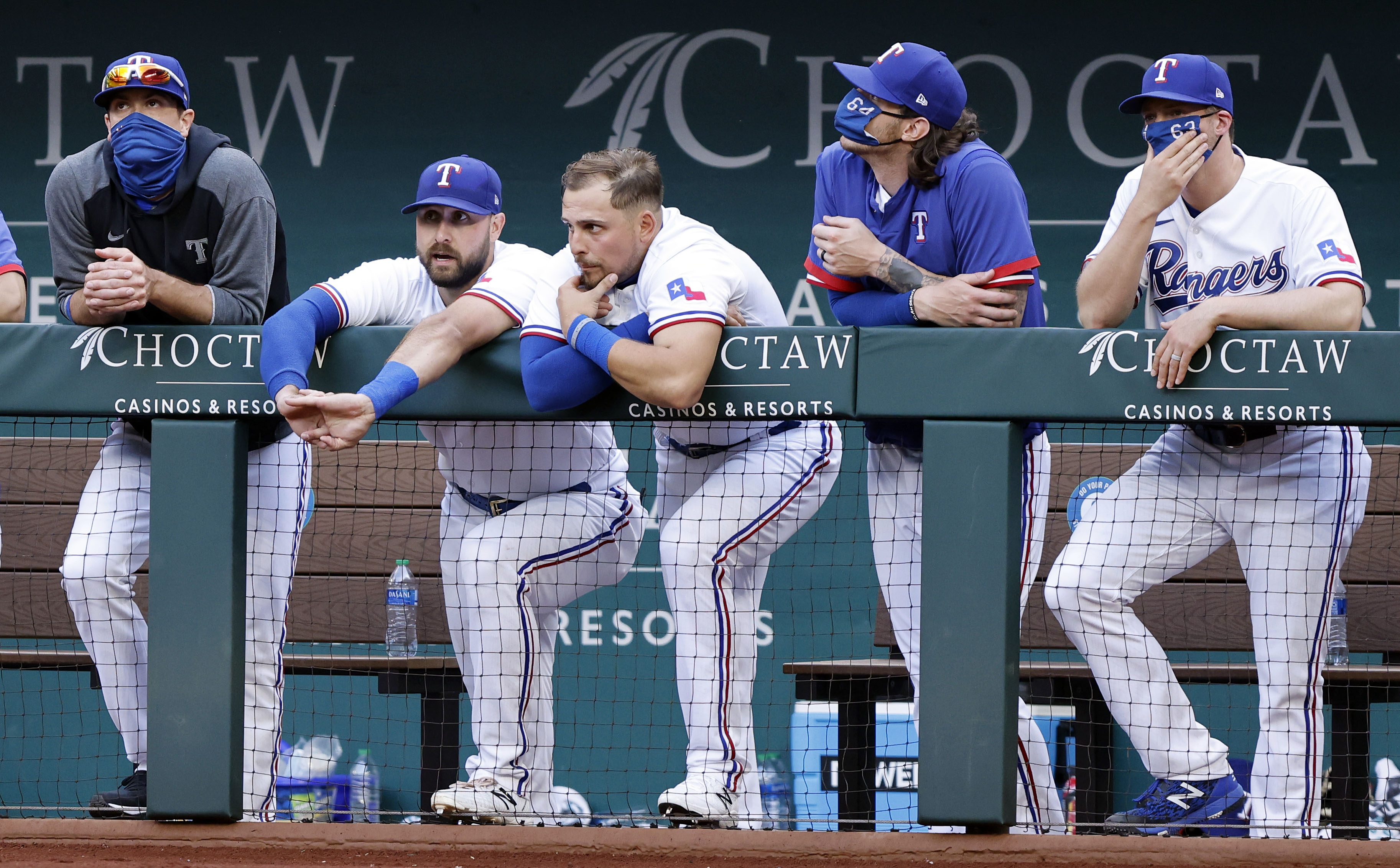 Texas Rangers players hang on the dugout rail late in the ninth inning against the Toronto...