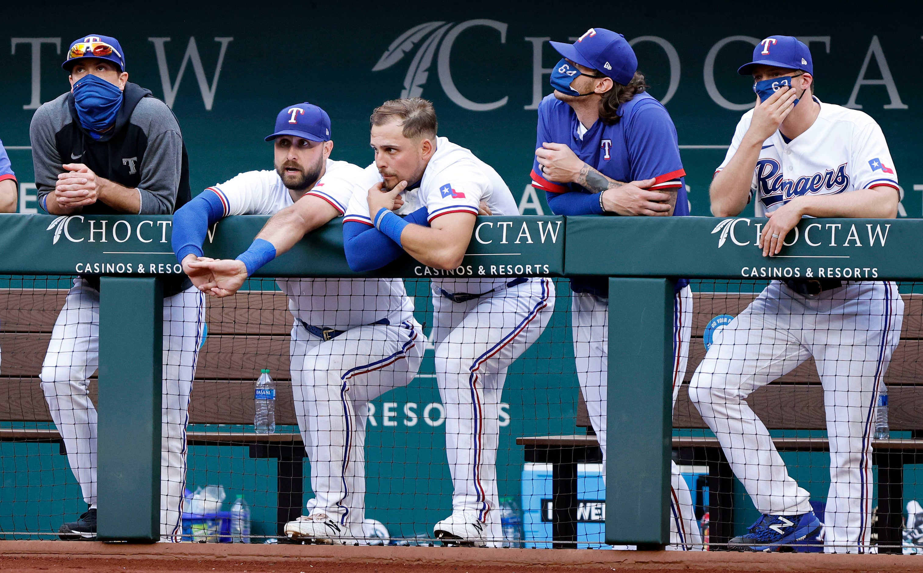 Texas Rangers players hang on the dugout rail late in the ninth inning against the Toronto...