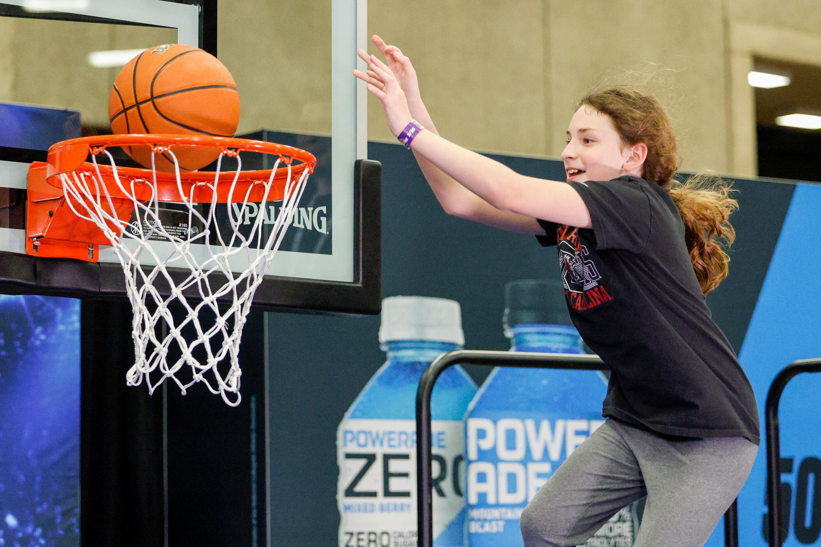 Addisyn Park, 8, dunks a ball at a Powerade booth during the NCAA women’s Final Four Tourney...