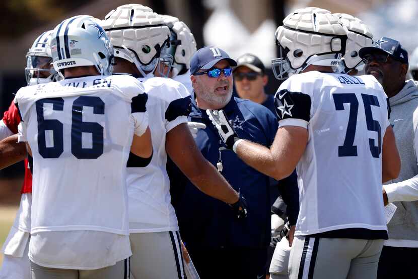 Dallas Cowboys head coach Mike McCarthy steps in and settles his offensive players who were...