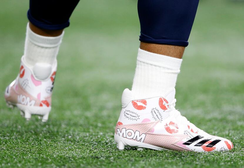 Dallas Cowboys quarterback Dak Prescott (4) works out with a pair of shoes dedicated to his...