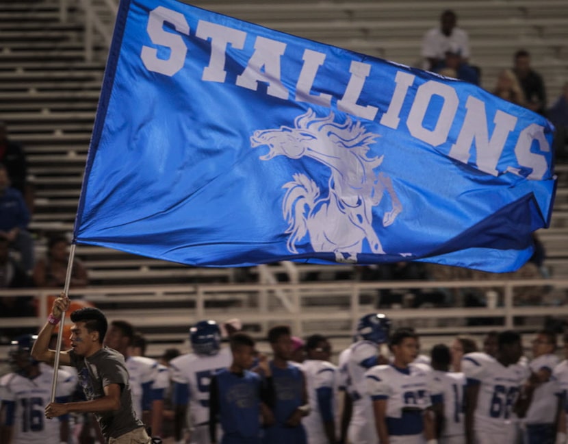 A North Mesquite flag bearer celebrates the first touchdown of the football game between...