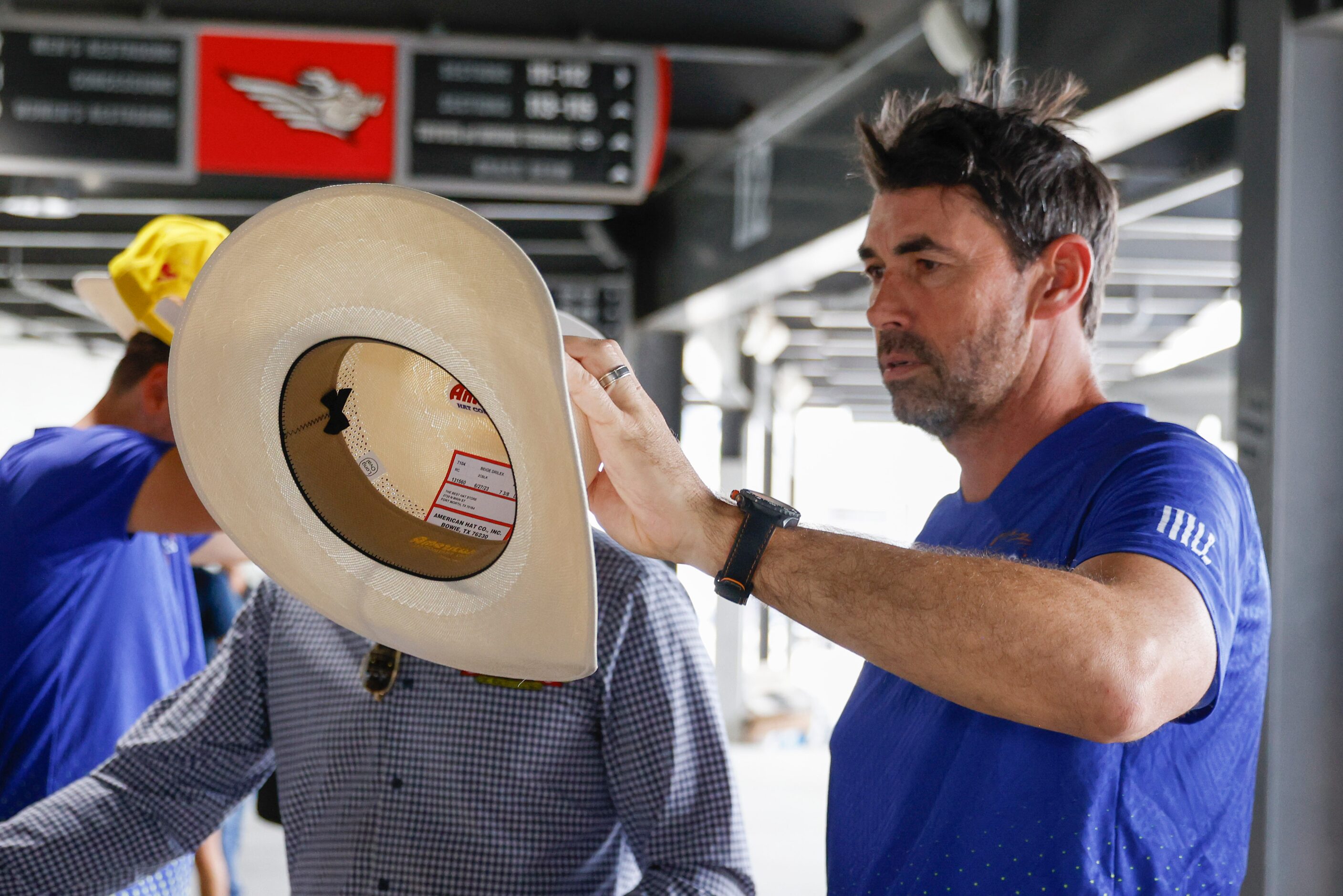 Texas Super Kings head coach Stephen Fleming checks out a cowboy hat given to the players...