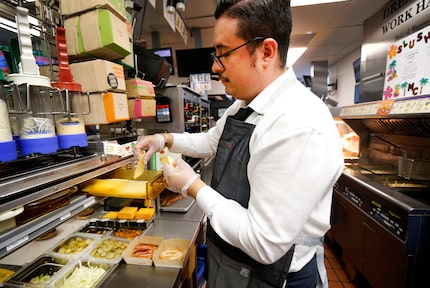 General Manager Carlos Soto grabs two slices of gouda to put on Spain's Grand McExtreme...