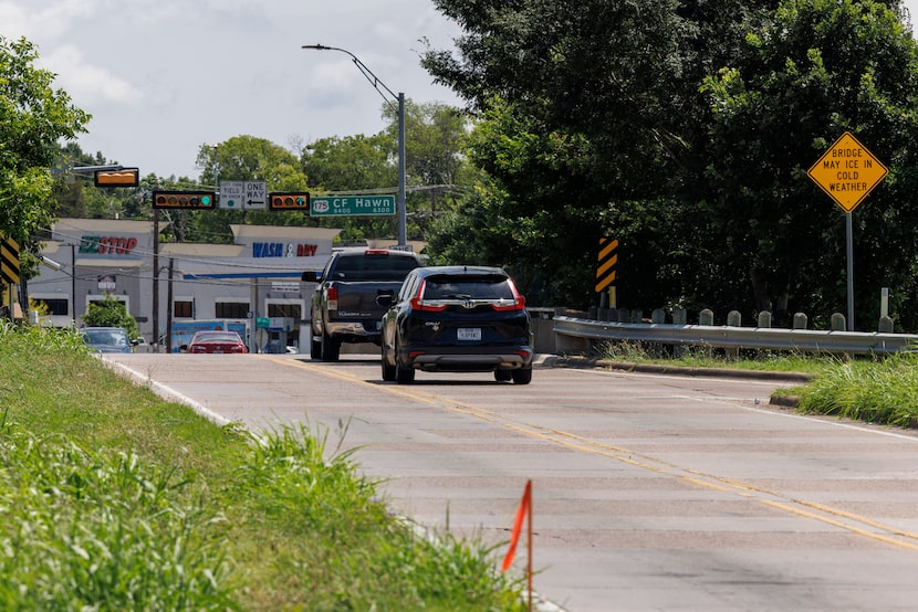 Cars pass over C.F. Hawn Freeway on the narrow Lake June Road bridge June 26. The Texas...