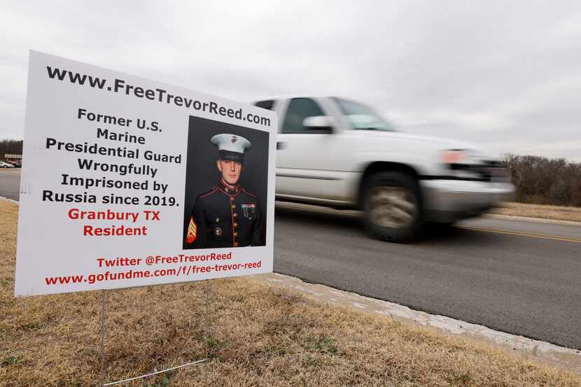 A truck drives past a sign for imprisoned former Marine Trevor Reed near the Tarrant County...