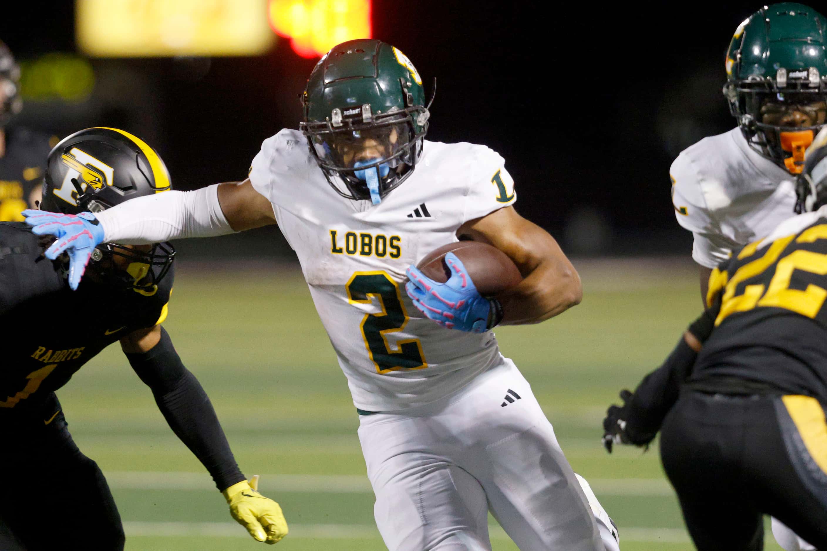 Longview's Taylor Tatum (2) carries the ball against Forney players during the first half of...