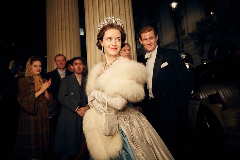 This image released by Netflix shows Claire Foy, center, and Matt Smith, right, in a scene...