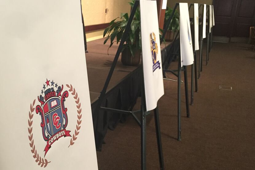 Eight easels, including one for Carter High School, sat at the front of a conference room at...