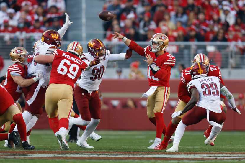 San Francisco 49ers quarterback Brock Purdy (13) throws to a receiver as he is pressured by...