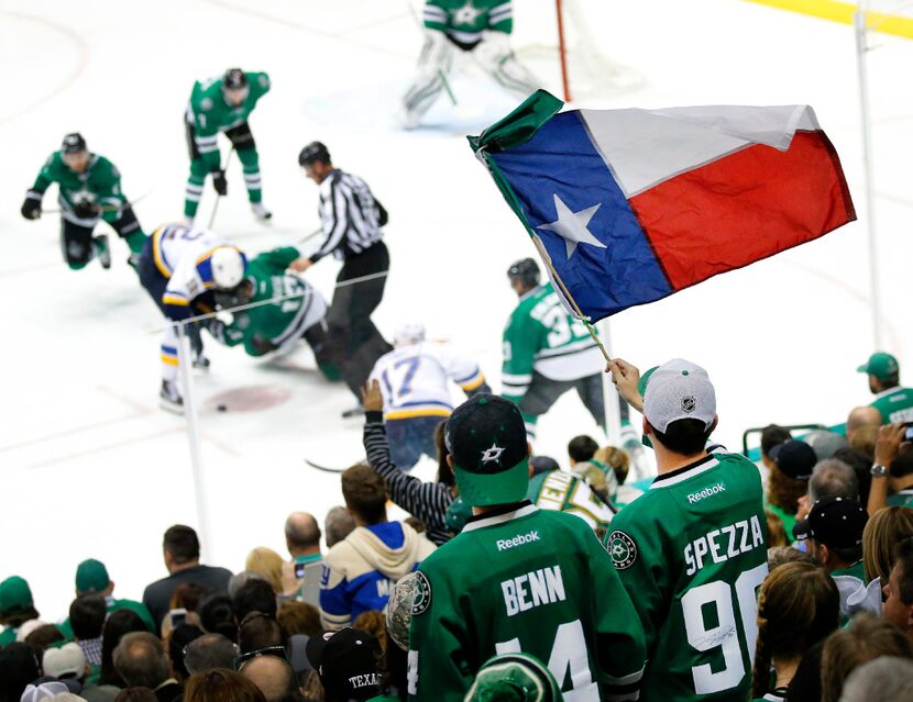 A Dallas Stars fan waves the Texas flag as the Stars and St. Louis Blues face off during the...