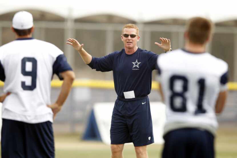 Dallas Cowboys head coach Jason Garrett talks with Dallas Cowboys quarterback Tony Romo (9)...