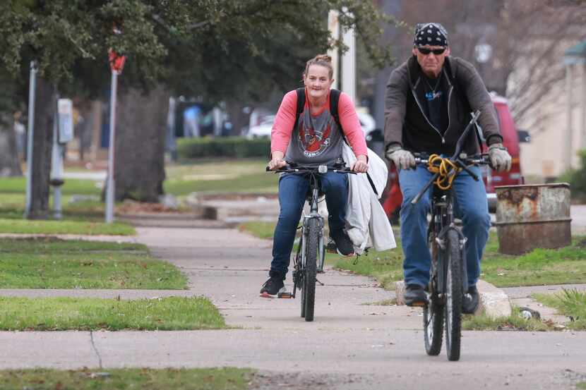 Two cyclist ride bikes on the sidewalk along Martin Luther King Jr Blvd, Thursday, Dec. 8,...