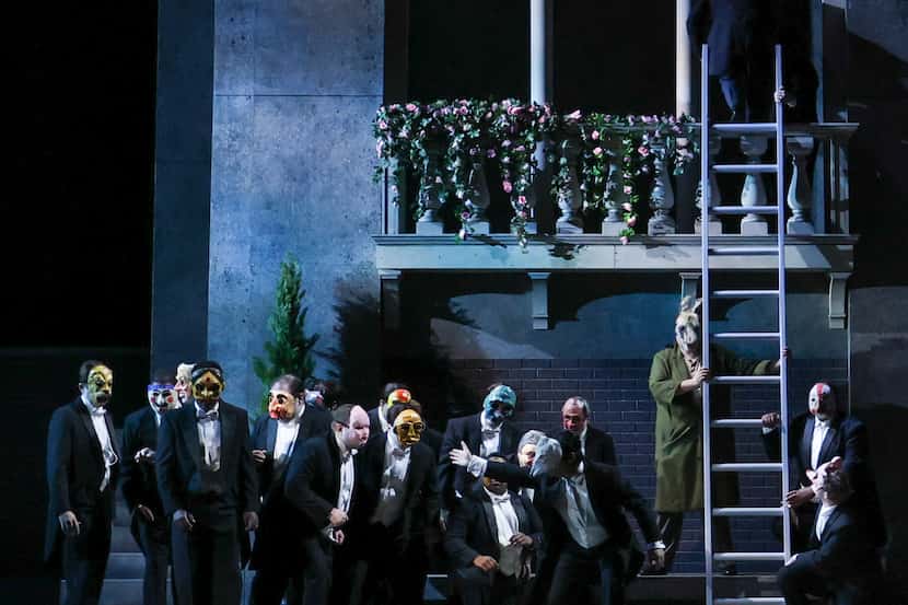 Rigoletto (in green robe holding the ladder), played by George Gagnidze, is blindfolded and...
