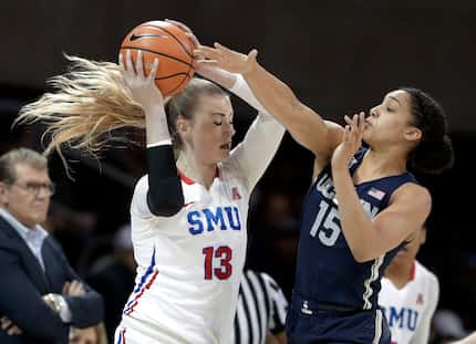 SMU's Klara Bradshaw (13) protects the ball as Connecticut forward Gabby Williams (15)...