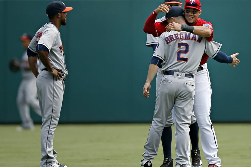 Texas Rangers left fielder Carlos Gomez (far right) hugs former teammate Alex Bregman before...