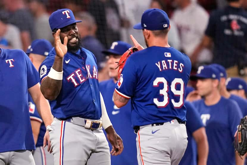 Texas Rangers' Adolis García celebrates with pitcher Kirby Yates (39) after defeating the...