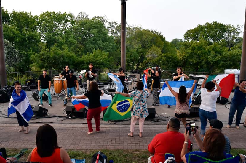 Salsa fans dance with a collection Latin flags during a performance by Havana NRG during the...