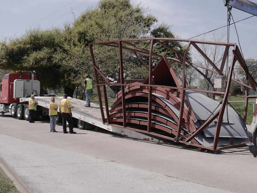  Workers load up the cargo of an 18-wheeler that struck a railroad bridge in Dallas Tuesday.