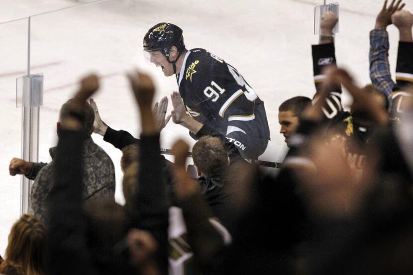 Fans and Dallas Stars center Brad Richards (91) react to Richards' goal during second period...