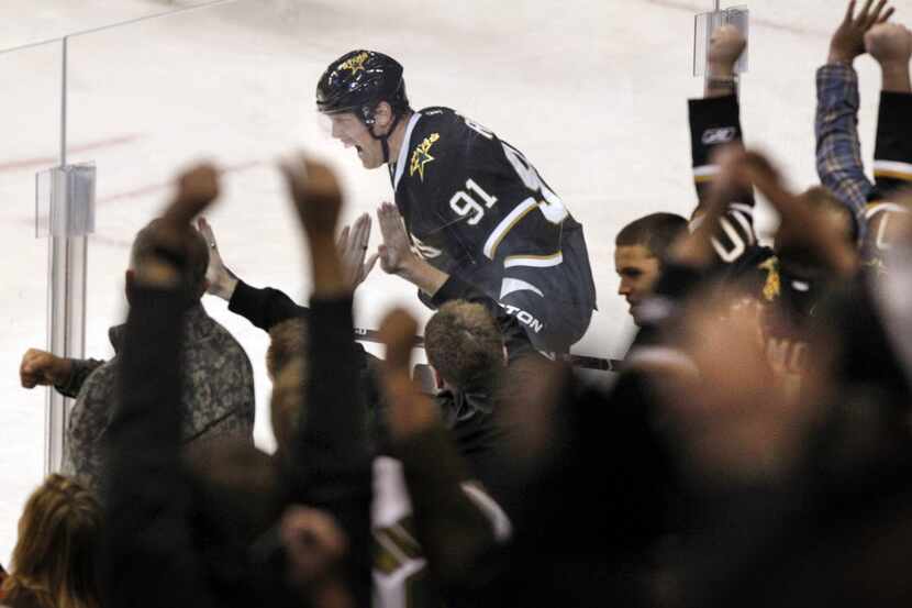 Fans and Dallas Stars center Brad Richards (91) react to Richards' goal during second period...