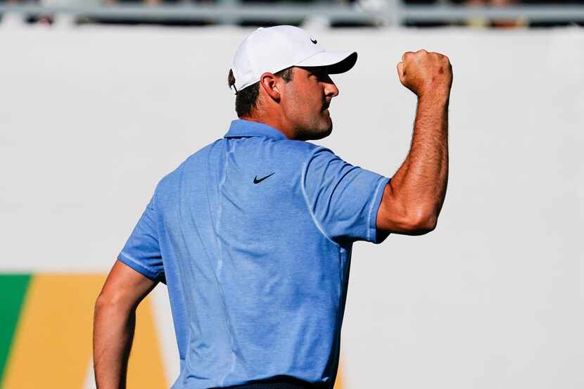 Scottie Scheffler pumps his fist after making par on the 16th hole of the final round of the...