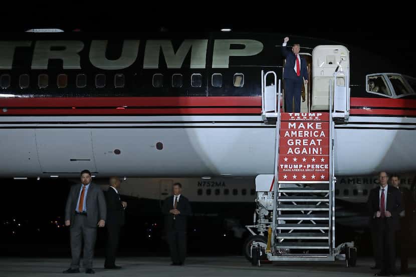 Republican presidential nominee Donald Trump throws his fist into the air as he steps off...