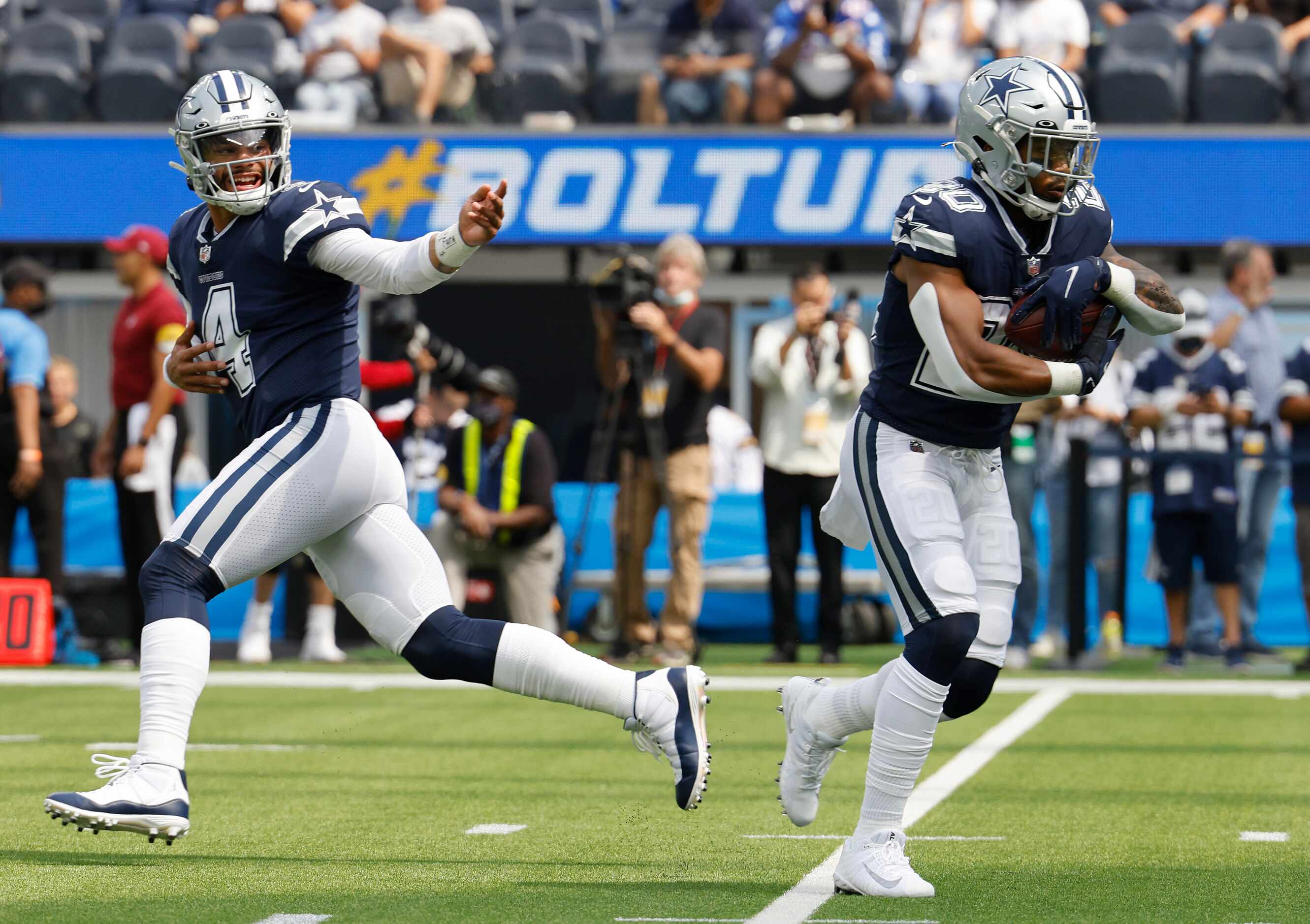 Dallas Cowboys quarterback Dak Prescott (4) hands off to running back Ezekiel Elliott (21)...
