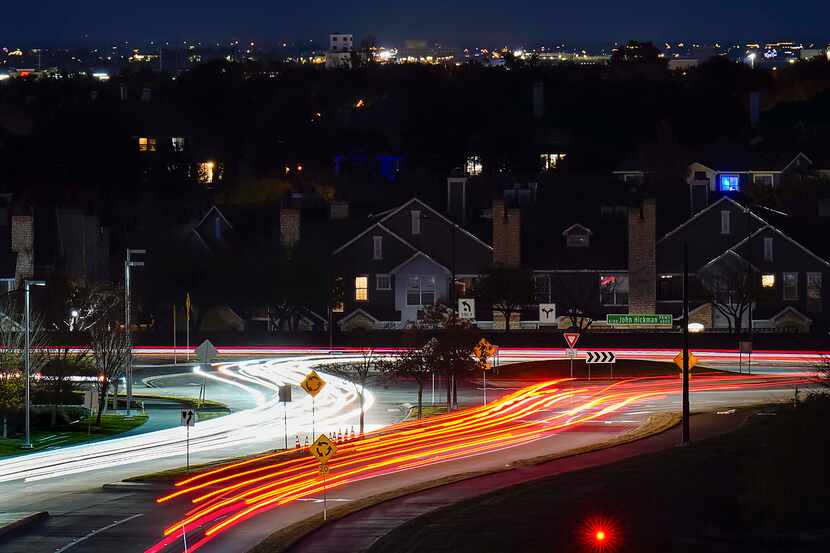 A long exposure shows the lights of cars  maneuvering a roundabout at Gaylord Parkway and...