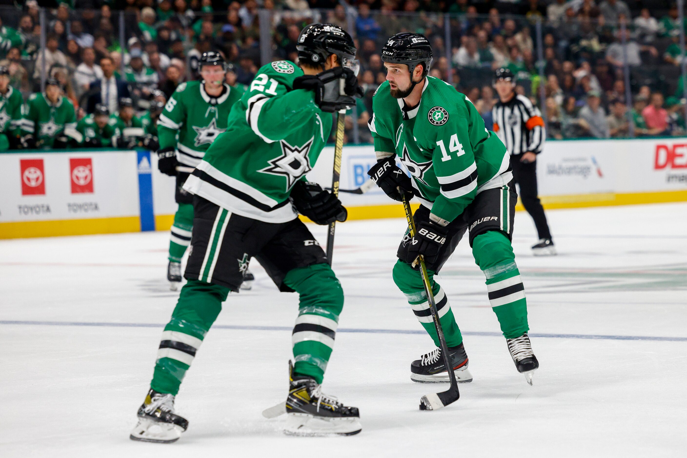 Dallas Stars left wing Jamie Benn (14) skates with the puck near left wing Jason Robertson...