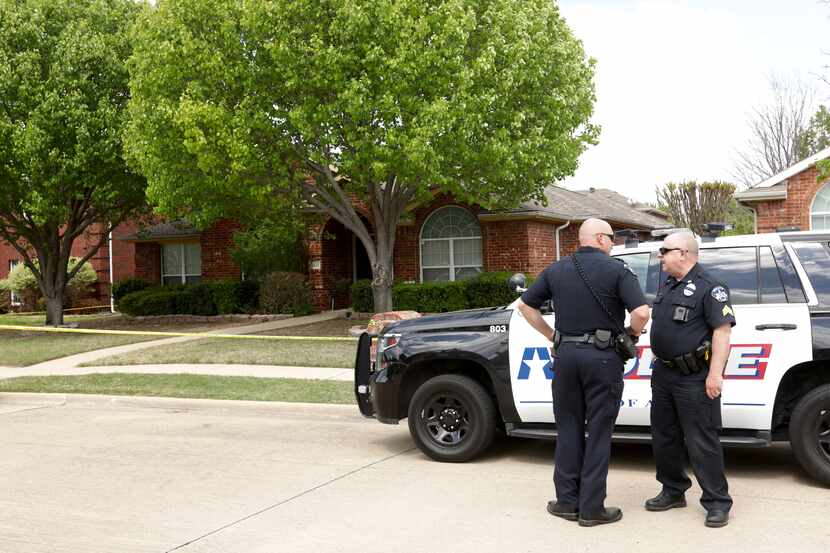 Police stand outside a home in Allen where six people were found dead Monday.