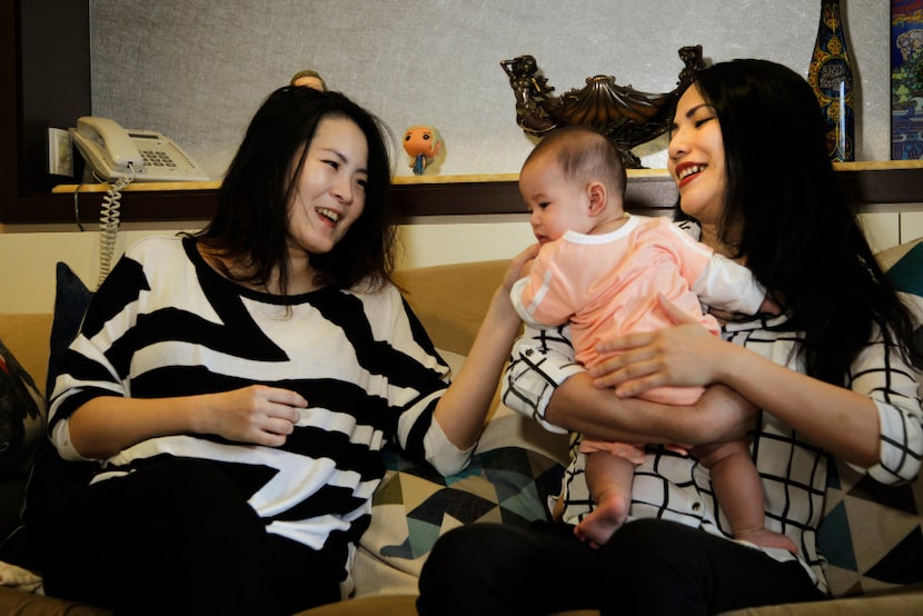 In this photo taken on Friday, Nov. 4, 2016, Cindy Su, left, and Lana Yu hold their baby...