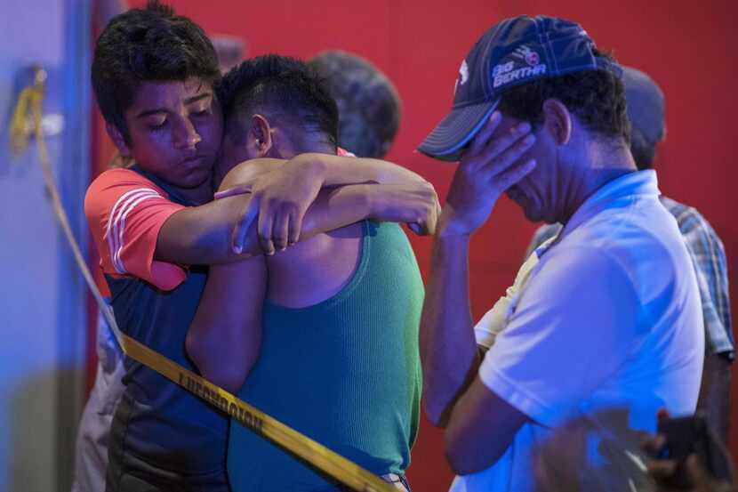People react outside a bar where 23 people were killed by a fire in Coatzacoalcos, Veracruz,...