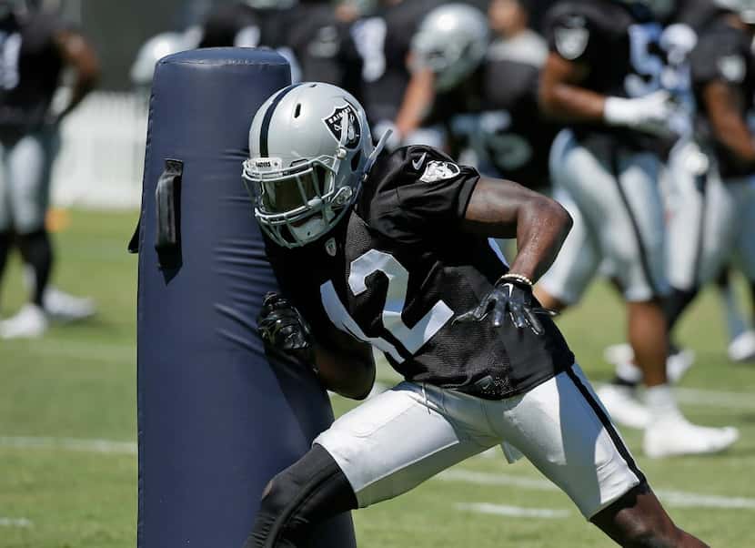 Oakland Raiders safety Karl Joseph hits a dummy during practice at the NFL football team's...