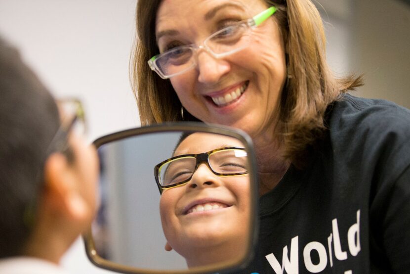 Diane Hirtriter of Kids Vision for Life, helps Damian Garcia, 8, of Carrollton, Texas pick...