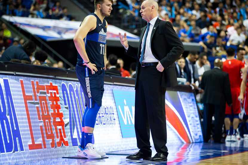 Dallas Mavericks guard Luka Doncic (77) talks with head coach Rick Carlisle before checking...