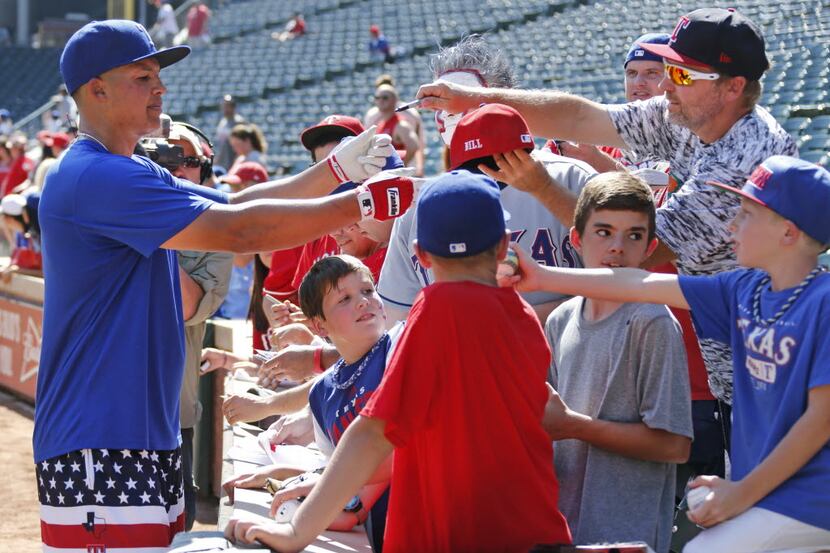 Texas Rangers left fielder Will Venable (30) signs autographs for fans before Game 4 of the...