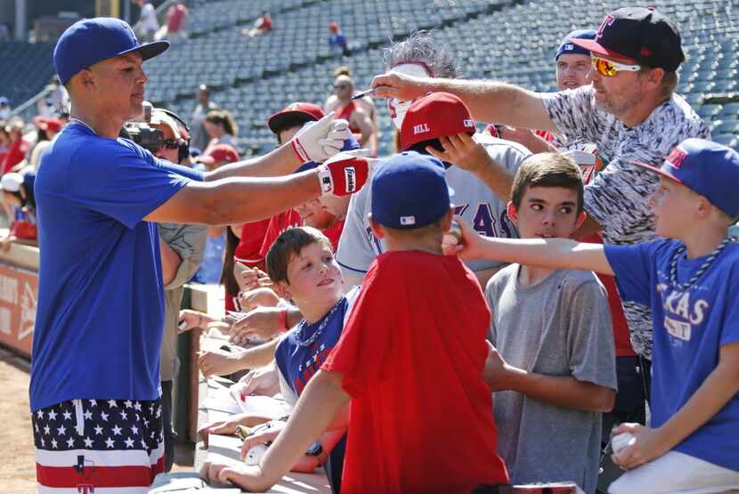 Texas Rangers left fielder Will Venable (30) signs autographs for fans before Game 4 of the...