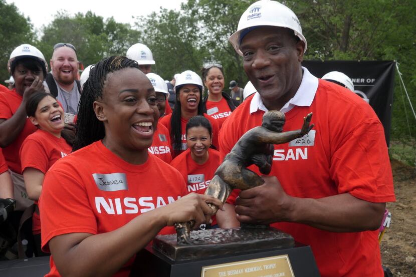 Homeowner Jessica Hunter and Heisman Trophy winner Billy Sims pose with the Heisman Trophy...