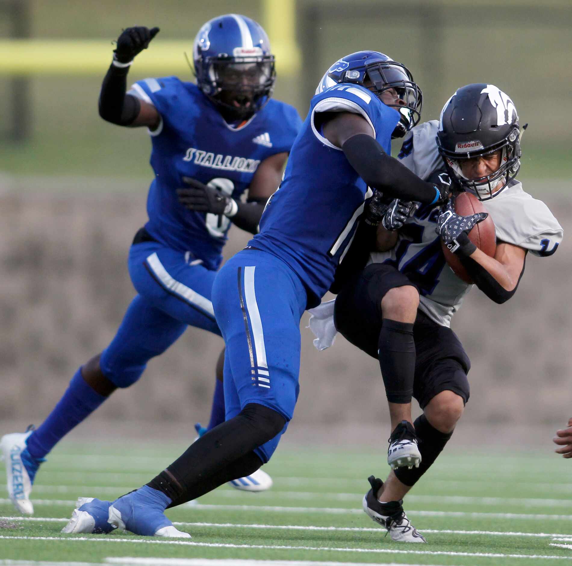 Plano West receiver Rawad Al Jazaerli (14), right, winces as he is hit by North Mesquite...