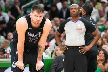 Dallas Mavericks guard Luka Doncic pauses as guard Jaden Hardy prepares to check in for him...