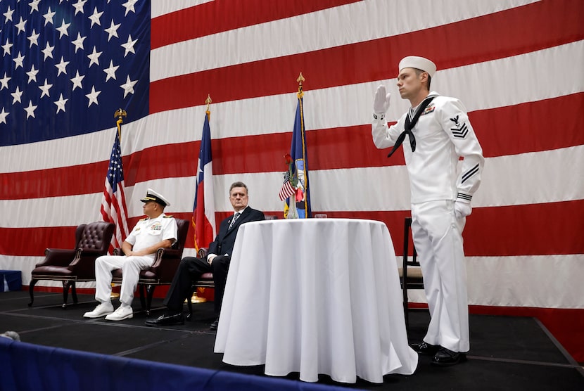 Yeoman 1st Class Blake Fuchs (right) salutes as the bell tolls while setting a table during...