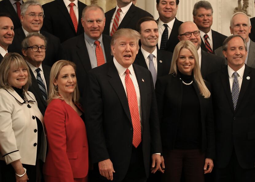 U.S. President Donald Trump (C), poses for a photo with members of the National Association...